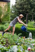 Woman watering plants in backyard