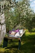Entspannen im mediterranen Garten mit Hängematte und Kissen