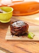 Beef steak wrapped in bacon with a slice of lime