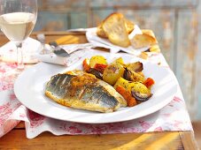 Sea bass fillets with vegetables and a glass of white wine