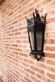 Italianate lantern style sconce on brick wall