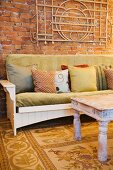Vintage Sofa mit Kissen vor rustikaler Ziegelwand