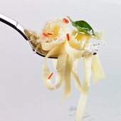 Tagliatelle, chilli, basil and grated Parmesan on a fork