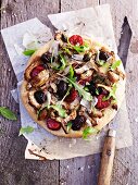 An artichoke, chorizo, black olive and rocket pizza