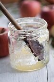 A wooden spoon in an empty jar of apple sauce
