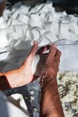 Raw milk sheep's cheese being kneaded by hand and placed in moulds (Portugal)