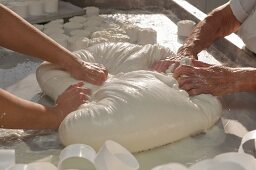 Raw milk sheep's cheese being kneaded by hand and placed in moulds (Portugal)