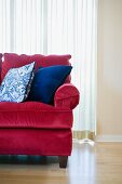 Red sofa with blue accent throw pillows