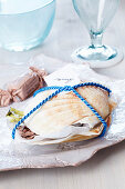 Small present: scallop shells filled with sweets and tied with cord holding name card