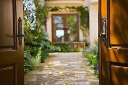 Stone path leading into Spanish style courtyard with fountain.