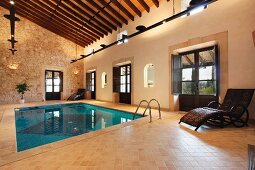 Indoor Pool in mediterranem Landhaus mit Natursteinwand
