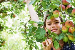 Smiling girl playing in fruit tree