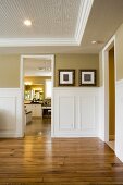 Image of empty room with wood floor looking into another room.