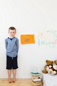 Boy with drawings on bedroom wall