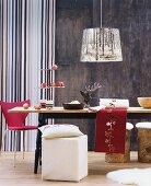 Wintery ornaments on wooden table, cubic pouffe and pendant lamp with photographic print lampshade