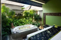 Spa room with massage table and sunken bath tub