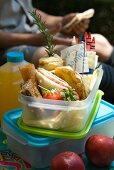 A lunch box containing a peanut butter and bacon sandwich, a miniature chicken and mushroom pie, and crispy potato skins