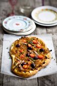 Pissaladiere with onions, sardines, olives and cherry tomatoes