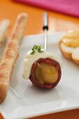 Potatoes wrapped in bacon and breadsticks for the cheese fondue