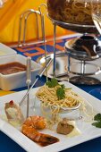 Fondue with prawns, tuna and egg noodles