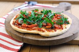 Pizza topped with tomatoes, rocket and mozzarella