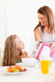 Mother pouring cereal for daughter