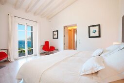 Modern white bedroom with red chair