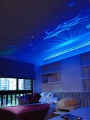 Unterwasserwelt an mystisch blau beleuchteter Decke in Kinderzimmer mit Teddys auf dem Bett
