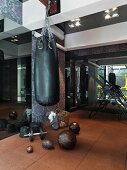 Elegant home gym with punchbag against floral patterned wall and dark mirrors