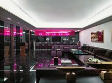 Klassisch moderne Lounge mit dunklem Interieur, pinkfarbener Leuchtinstallation und Deko im asiatischen Stil