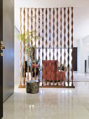 Transparenter Raumteiler aus spiralförmigen Holzleisten im modernen Vorraum