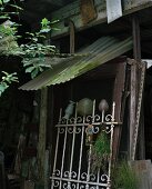 Wrought iron fence in front of discarded wooden frames in barn-like room