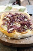 Pizza topped with gorgonzola cheese, red onions and apple slices