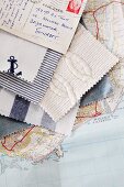Fabric swatches in maritime styles and stamped postcard fanned out on top of map