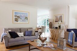 Scandinavian maritime style with glass-topped console table artistically crafted from roots in seating area of open-plan living room