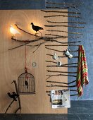 Ladder-like suspended rack made of branches & various ornaments with bird motifs