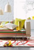 Sofa with striped upholstery and scatter cushions, small side table and wicker pendant lamps