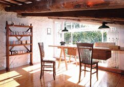 Light-flooded, innovative home office with whitewashed stone wall, wooden floor and massive ceiling beams in front of large window