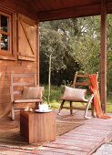 Simple wooden veranda with comfortable rocking chairs and wooden cube as side table