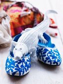 Crocodile ornament on blue and white slippers with floral embroidered pattern