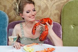 Woman holding lobster in restaurant