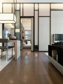 Modern writing desk with art deco hanging lamp in front of a wooden partition wall in a living room