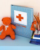 Teddy bear next to hand-crafted photo album with blue gingham cover