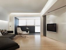 Minimalistisches Wohnzimmer mit Flatscreen und abgehängter Decke mit indirekter Beleuchtung
