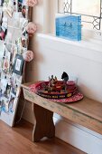 A serving tray with small figurines and tea lights on a wooden bench