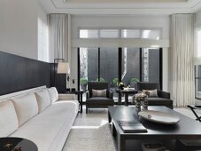 Langes Sofa und grosser Holztisch im schwarzweissen, modernen Wohnraum