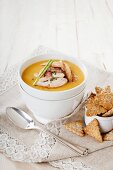 Cream of gold pea soup with chicken strips and homemade crackers
