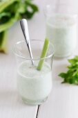 A smoothie garnished with a stick of celery and chives