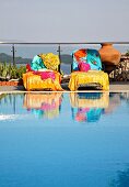 Colourful towels on loungers next to swimming pool on terrace (Villa Octavius, Lefkas, Greece)