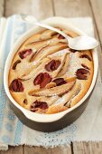 Pear and plum clafouti in a baking dish